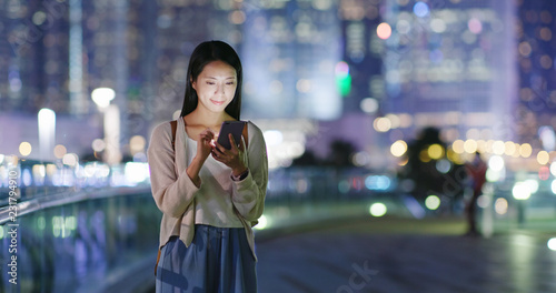 Woman use of mobile phone in city at night