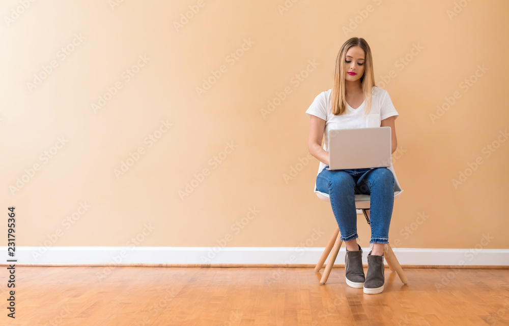 Young woman with a laptop computer in a chair