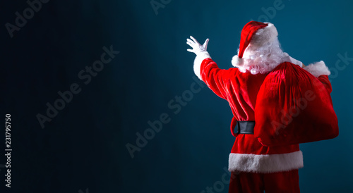 Santa holding a red sack on a dark blue background photo