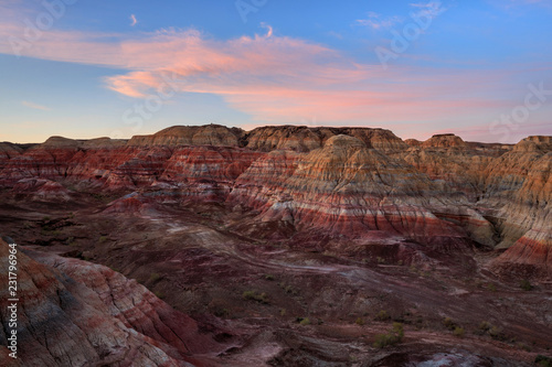 Rainbow Hills in China. Rainbow City, Wucai Cheng. Colorful layered landforms in a remote desert area of Fuyun County. Uygur Autonomous Region, Xinjiang Province. Sunrise - Pink, Purple and Blue Sky