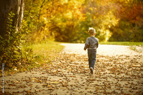 Boy running in leaves © April