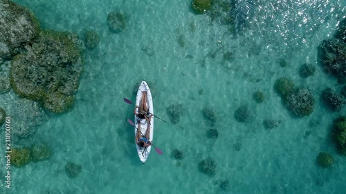 Aerial - Top view of couple paddling in canoe on crystal clear water