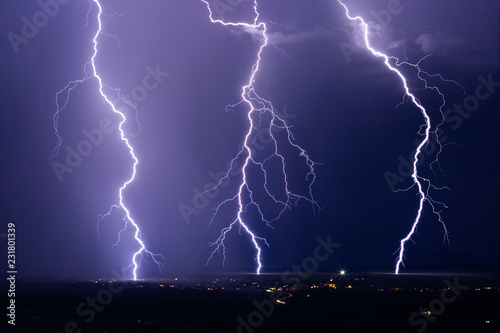 Lightning bolt strikes in a storm over a city