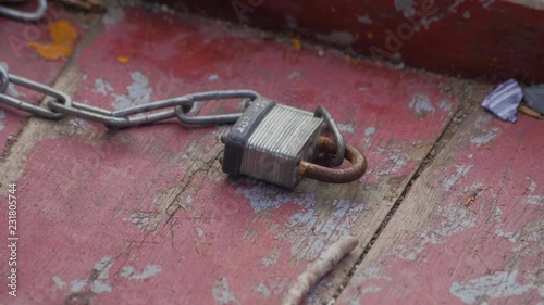 Old lock with a chain on red painted wood