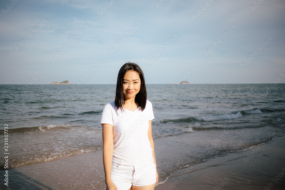 Happy and playful woman walk on the beach and play with the camera.