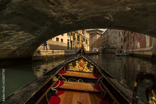 Inside gondola view as it going under the bridge on canals in Venice
