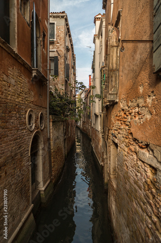 View on tight canal in Venice with beautiful architecture on a sunny day