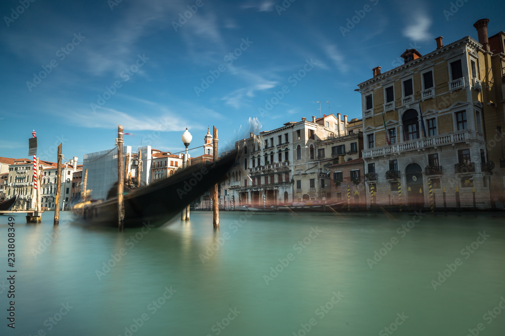 View on Grand Canal in Venice with parked gondola.Long exposure shot
