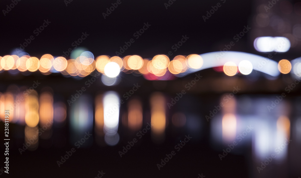Vibrant blurred city skyline with bokeh effect reflected on water