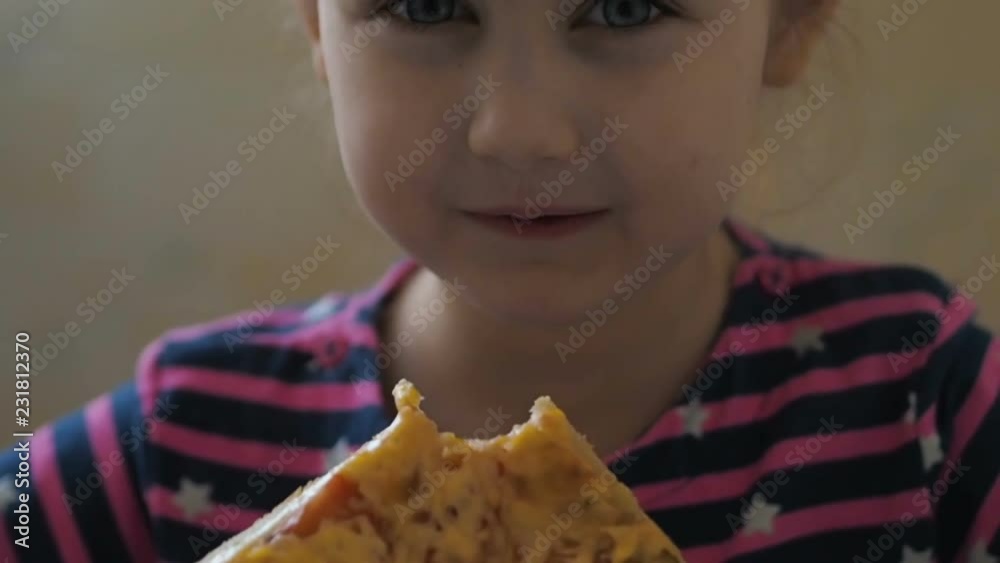 Cute little Caucasian girl eating pizza. Hungry child taking a bite from pizza.