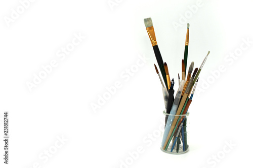 brush and other art tools in glass jar on white background