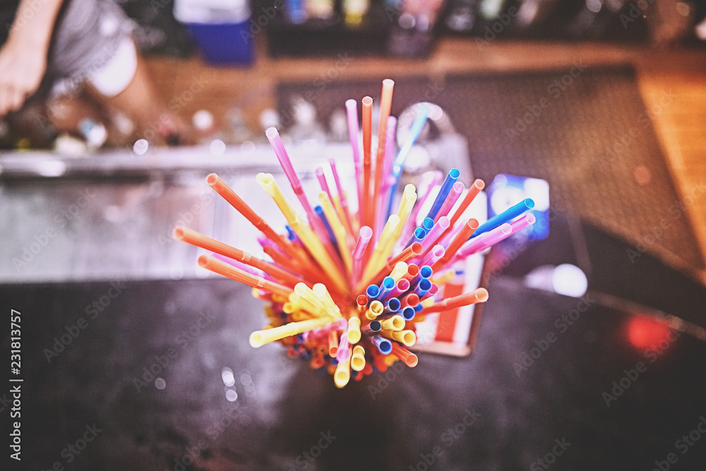 Colorful straws on wooden bar background. Event and party supplies.