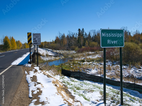 Mississippi River flowing north near its source at Itasca State Park in Minnesota. This sign is at the fifth highway bridge over the Mississippi River after an early autumn snowfall. photo