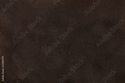 Dark brown matt suede fabric closeup. Velvet texture.