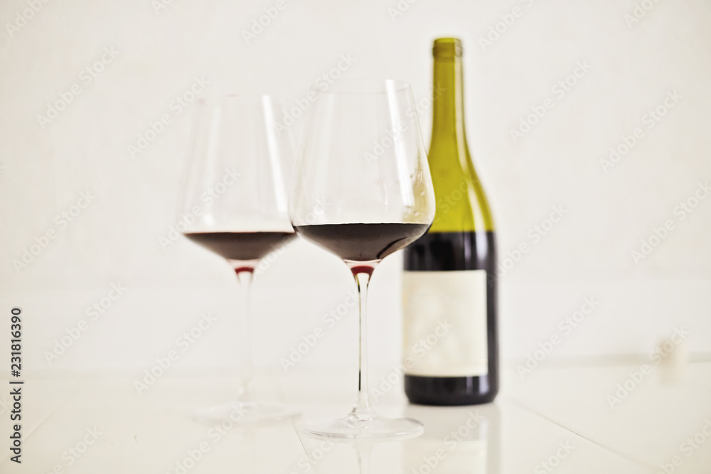 Red wine drinks in glasses with bottle on white background