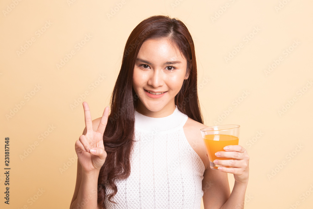Young Asian woman show victory sign drink orange juice. Young Asian woman show victory sign drink orange juice.
