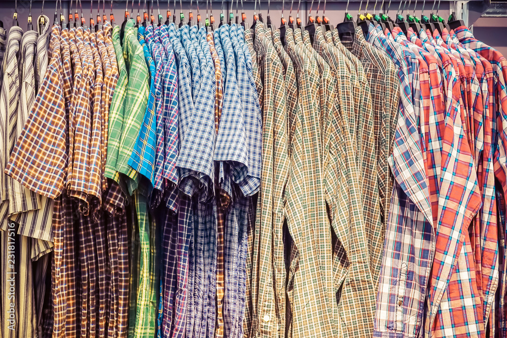 Many colorful checkered formal men shirts hanging on a rack, Row of men's  suits hanging in closet, concept of buy and sell, business man Stock Photo  | Adobe Stock
