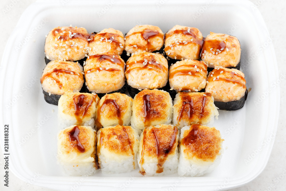 Sushi roll set in a white box. Hot baked rolls. Traditional Japanese food. Sushi roll set in a white box. Hot baked rolls. Traditional Japanese food.