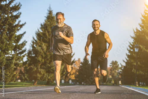 The happy father and a son running on the park road