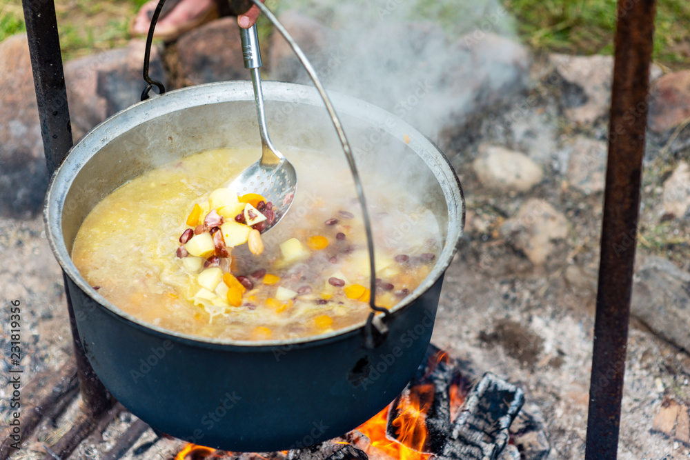 Cooking food in a pot on campfire. Summer camping concept. Cooking food in a pot on campfire. Summer camping concept.