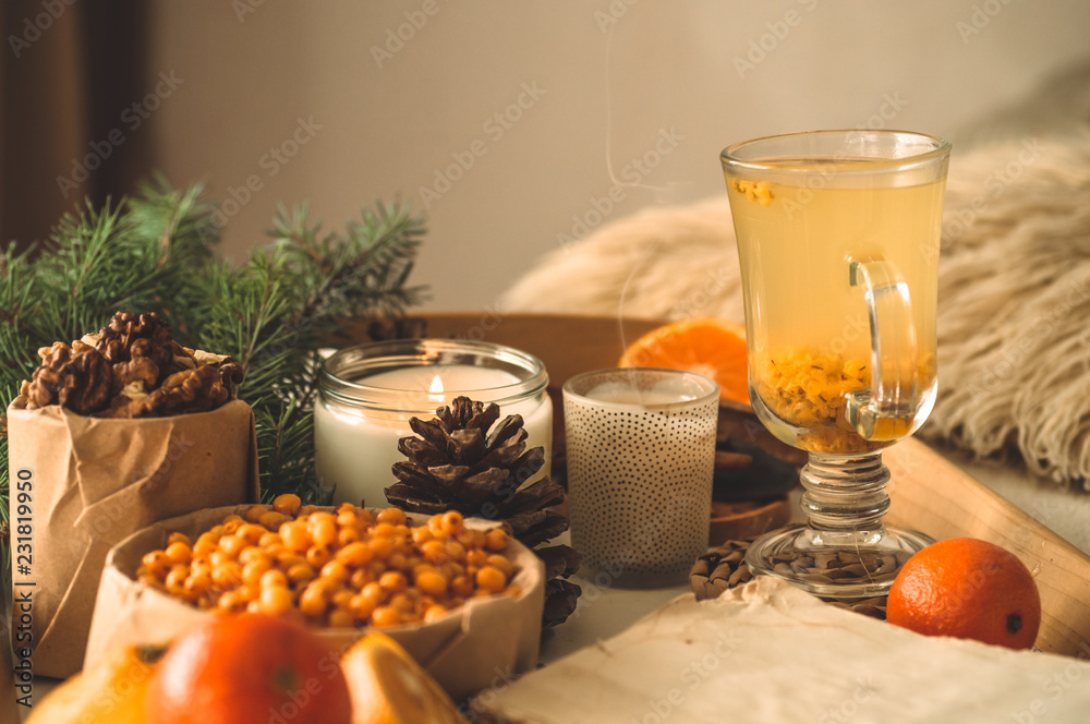 Still life with orange and sea buckthorn on a wooden background. Candle, tangerines.   Concept of seasonal vitamins 