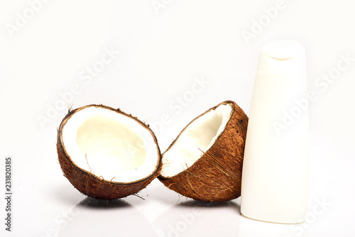 Close-up of Broken coconut and white bottle are isolated on white backgroun