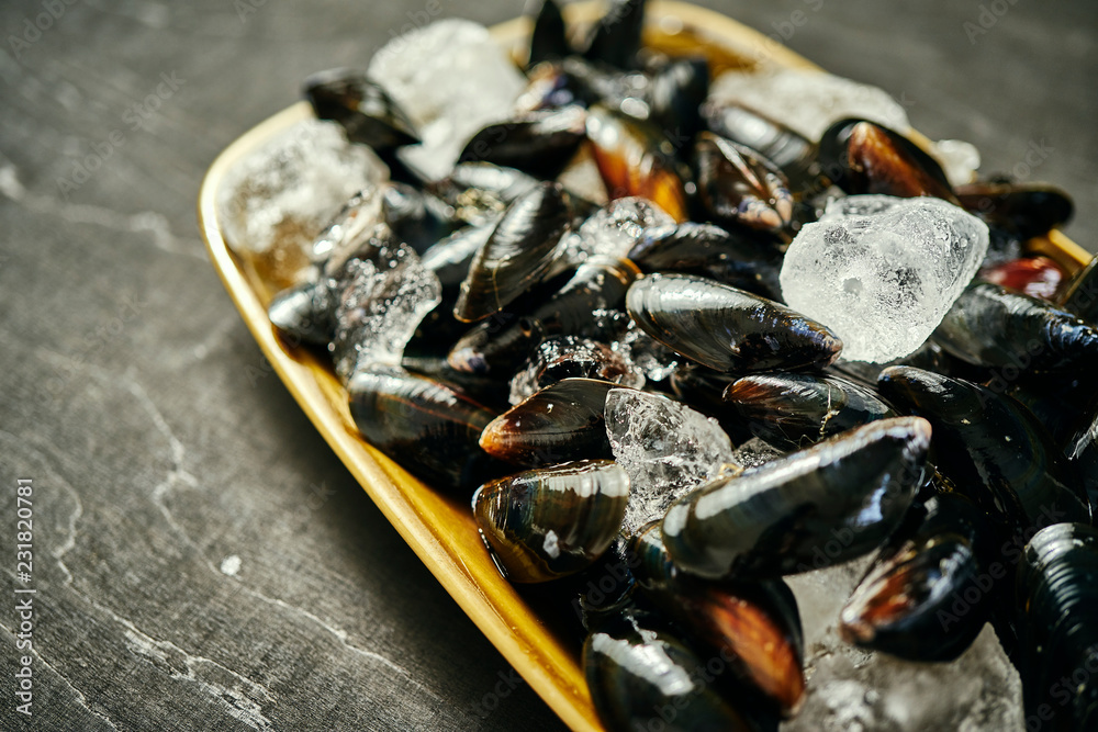 fresh delicious raw mussels served with ice on an old silver plate