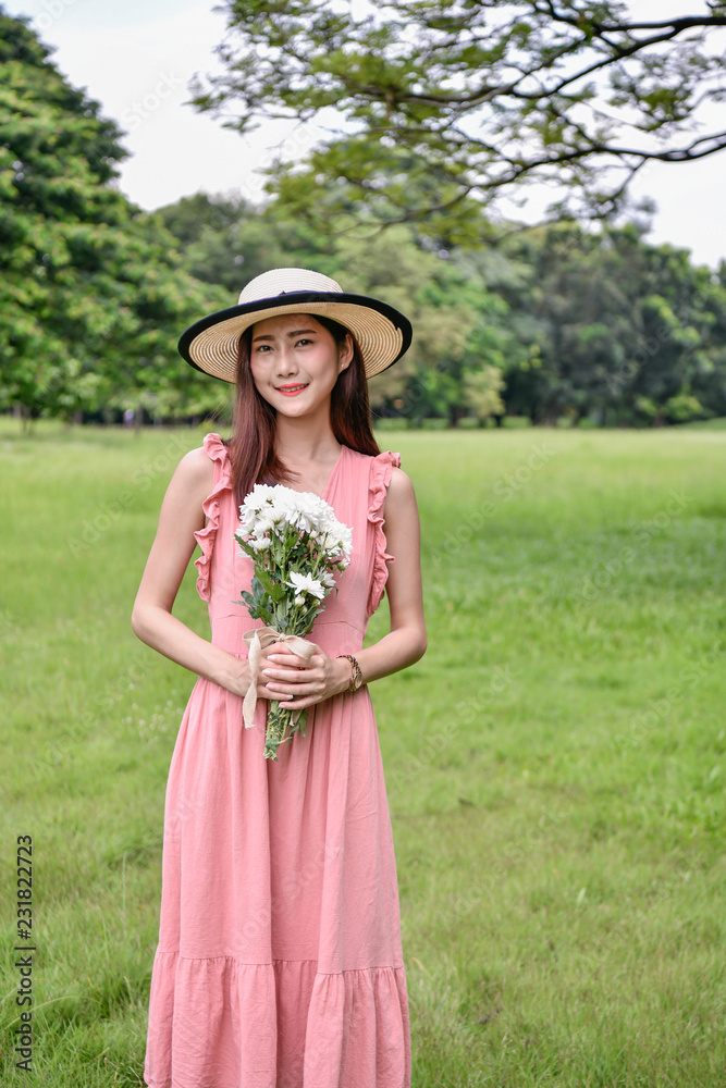 Holiday concept. Beautiful girl is getting flowers. Beautiful girl enjoys the scenery and nature.