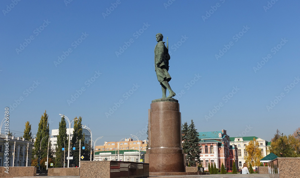 Fototapeta premium Monument to Zoya Kosmodemyanskaya on the background of the city in Tambov Russia.
