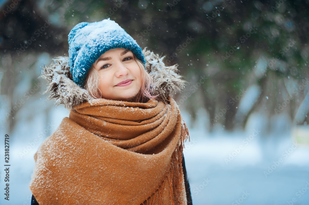 winter portrait of happy young woman walking in snowy forest in warm outfit, knitted hat and oversize scarf. Exploring nature on winter and Christmas vacations concept winter portrait of happy young woman walking in snowy forest in warm outfit, knitted hat and oversize scarf. Exploring nature on winter and Christmas vacations concept