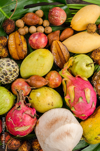 Assorted Thai tropical fruits on a dark wooden rustic background. photo