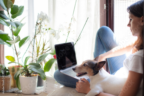 Attractive young woman working on a window seat