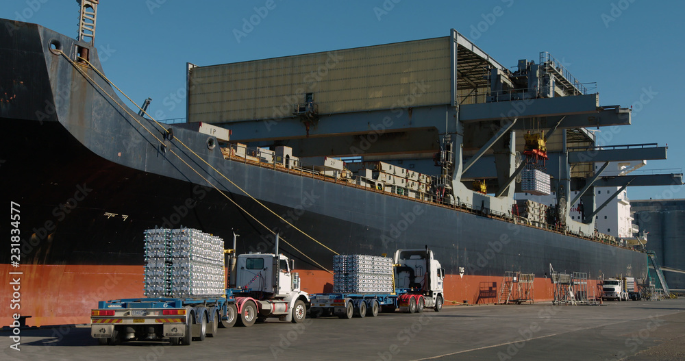 Trucks lining up to export aluminum from Australian port. Stock Photo