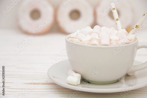 hot chocolate with marshmallow candy and Christmas decorations on white wooden background