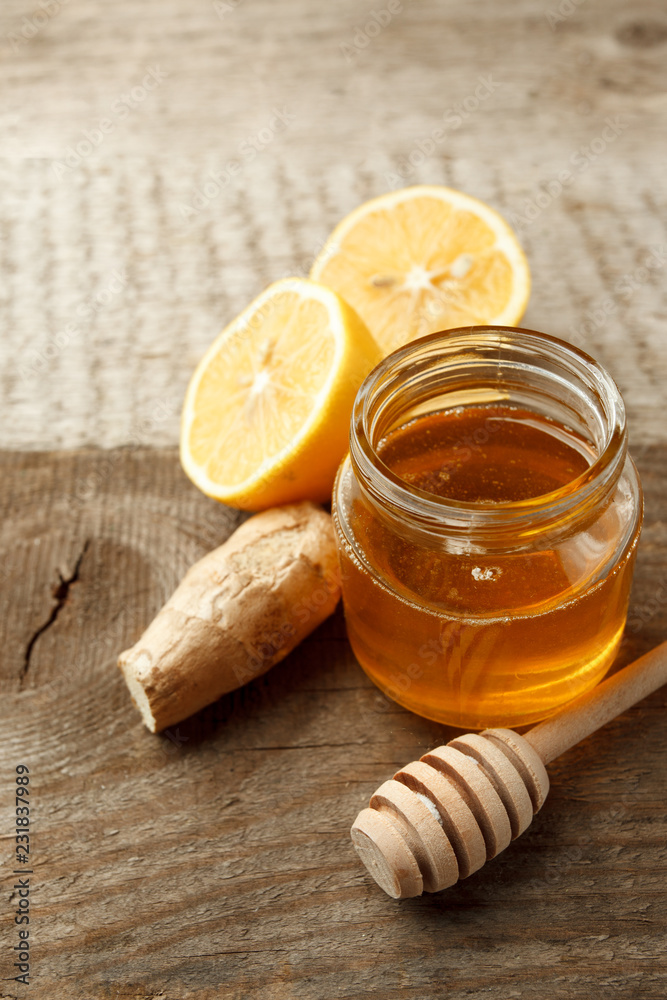 Composition with honey, lemon and ginger as natural cold remedies on white wooden background, flu remedy warming drink Composition with honey, lemon and ginger as natural cold remedies on white wooden background, flu remedy warming drink