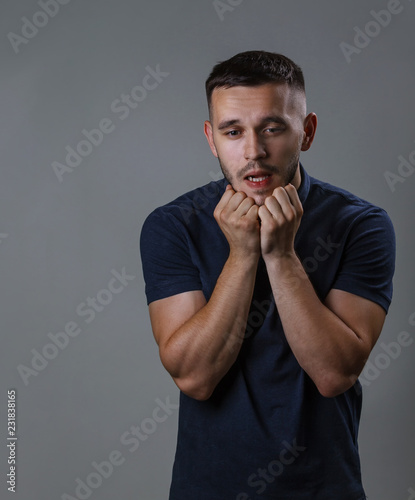 Perplexity concept. Closeup portrait of a handsome guy with hands on "jaw dropped" surprised, shocked, stunned and scared, with hands on chin, isolated on gray background