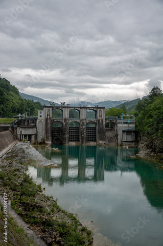Huge concrete dam on emerald colorful river