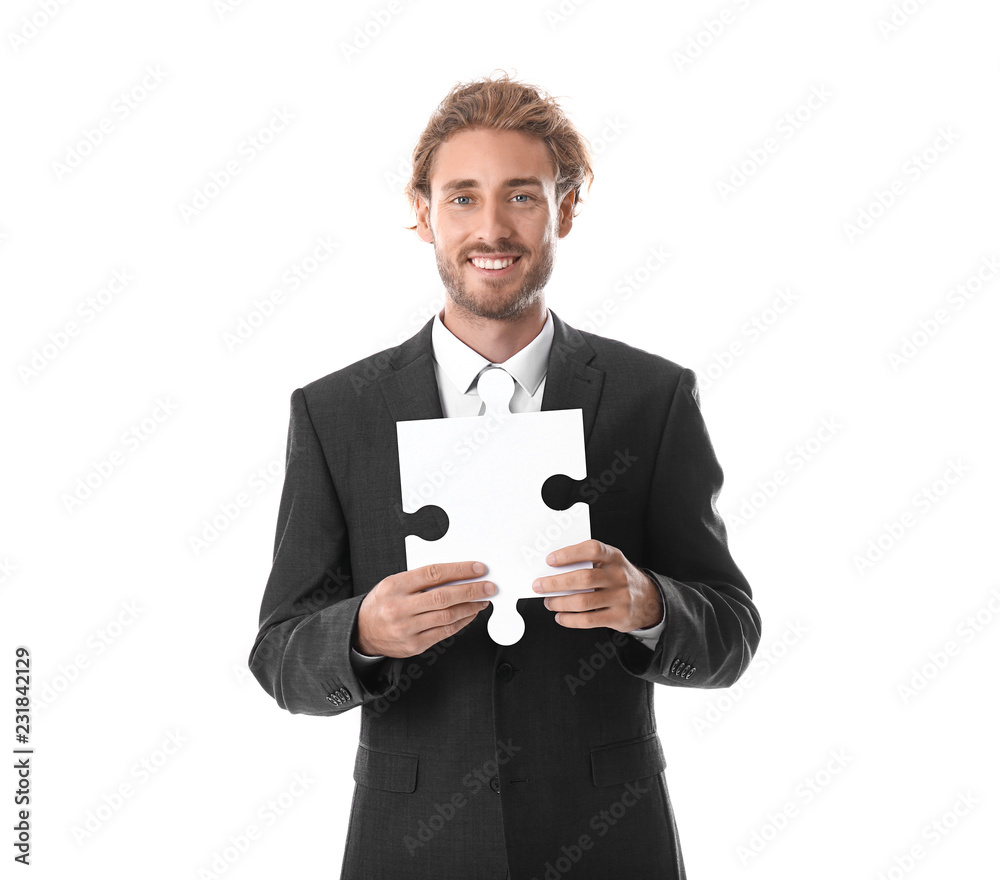 Young businessman with piece of jigsaw puzzle on white background Young businessman with piece of jigsaw puzzle on white background