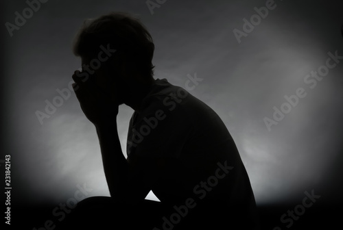 Canvas Print Silhouette of stressed man on dark background