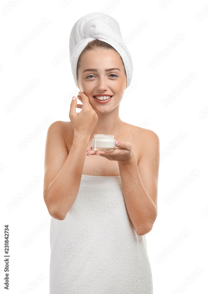 Beautiful young woman wrapped in towel holding jar of cream on white background Beautiful young woman wrapped in towel holding jar of cream on white background