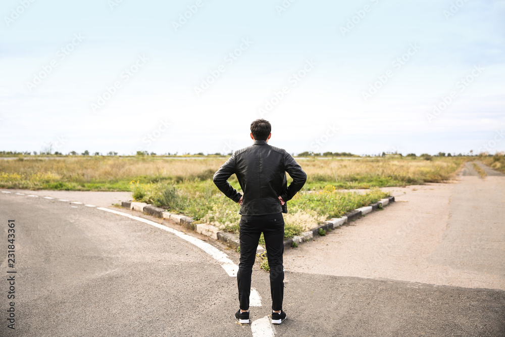 Young man standing at crossroads. Concept of choice Young man standing at crossroads. Concept of choice