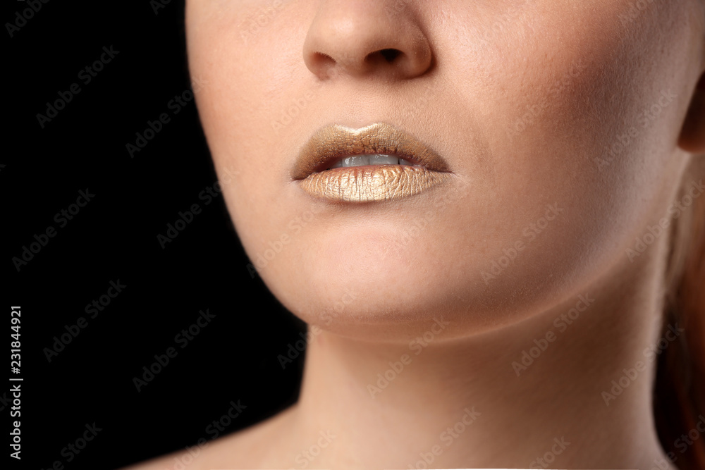 Beautiful woman with golden lips on black background, closeup Beautiful woman with golden lips on black background, closeup