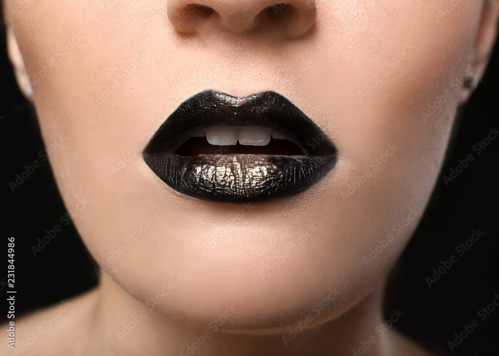 Fototapeta premium Young woman with extravagant make up in black and golden tones, closeup