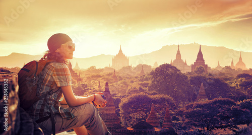 woman traveler sitting and looking sunset and enjoying the view stupas on Bagan
