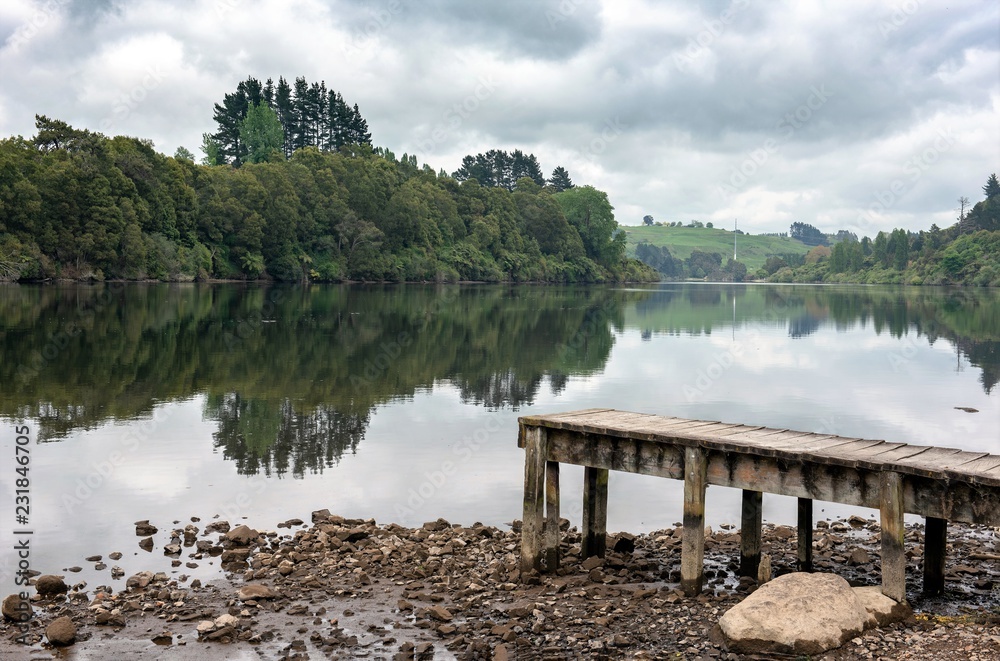 A wooden boardwalk jetty reaching out to still waters