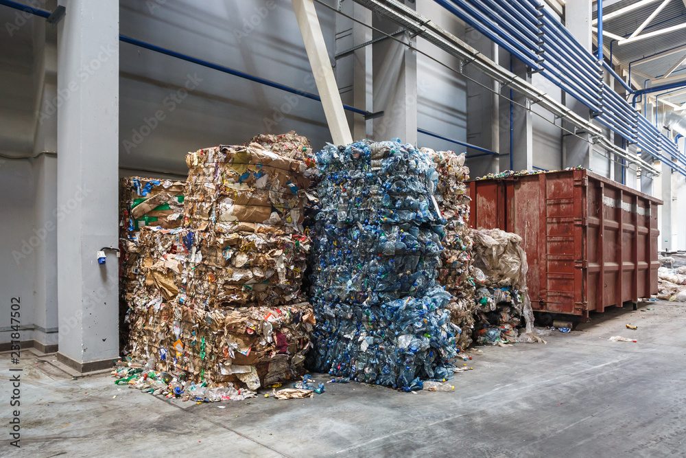 Plastic bales of rubbish at the waste treatment processing plant. Recycling separatee and storage of garbage for further disposal, trash sorting. Business for sorting and processing of waste.