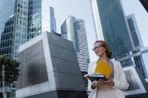 Beautiful young businesswoman among the skyscrapers of the modern business center