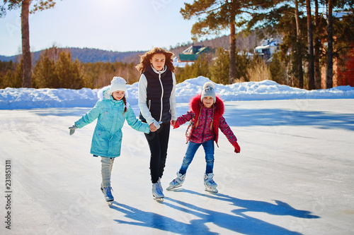a family skates together at an ice rink
