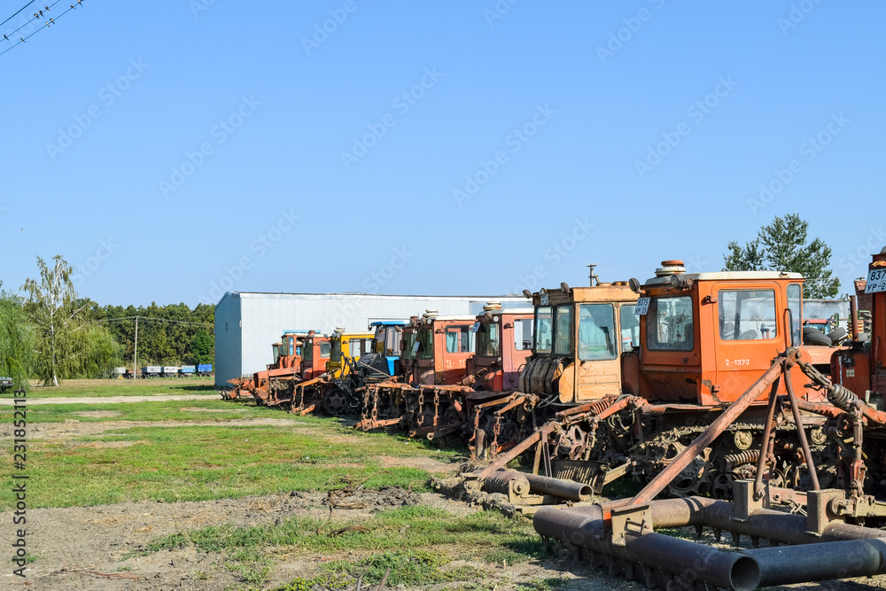 Obraz premium Russia, Temryuk - 15 July 2015: Tractor. Agricultural machinery tractor. Parking of tractor agricultural machinery. The picture was taken at a parking lot of tractors in a rural garage on the