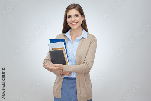 Smiling woman teacher holding books.
